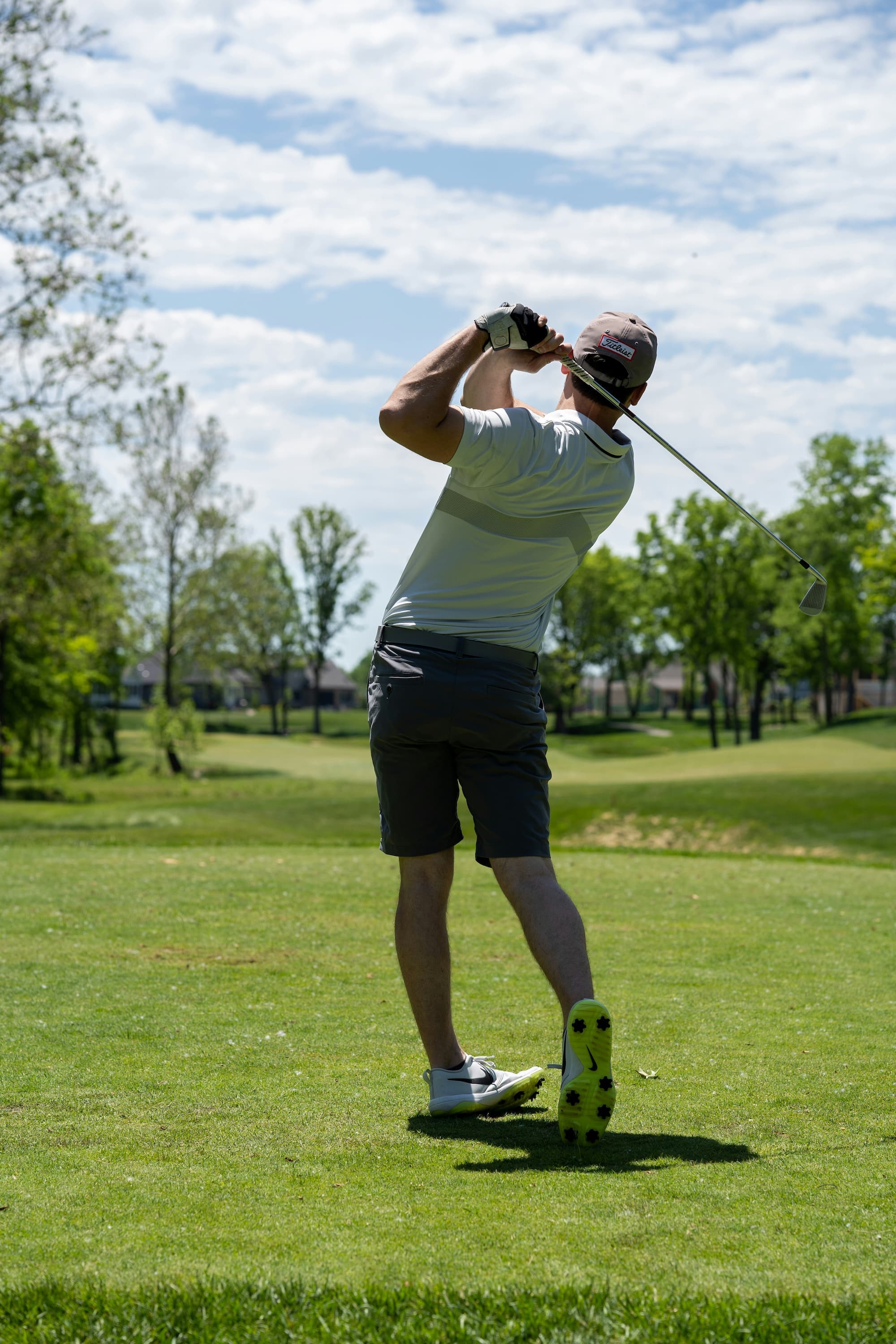 A golfer mid-swing on the fairway